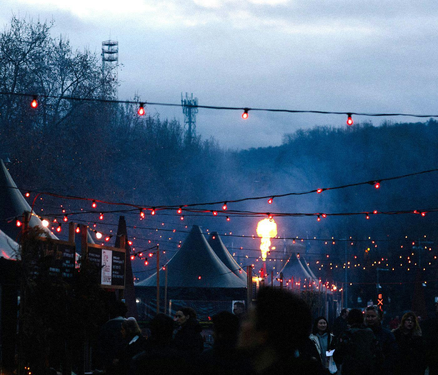 Outside at Winter Feast, strings of lights, people and stall gazebos stretch into the distance.